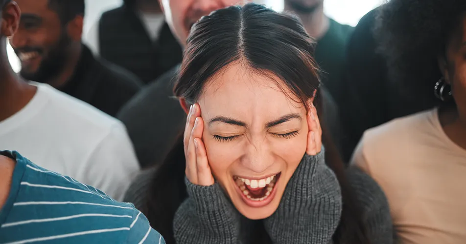 Person with hand over ears trying to steady their breathing during an anxiety attack